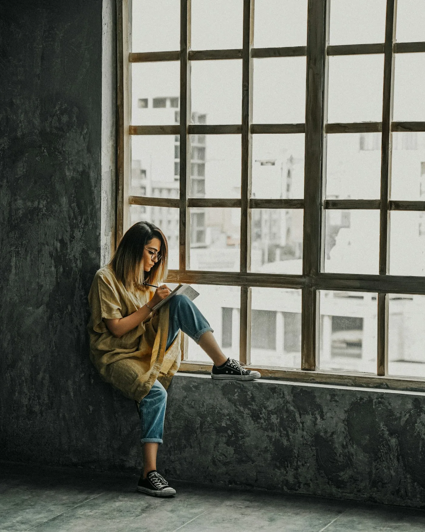 A woman taking a quiet moment beside a window