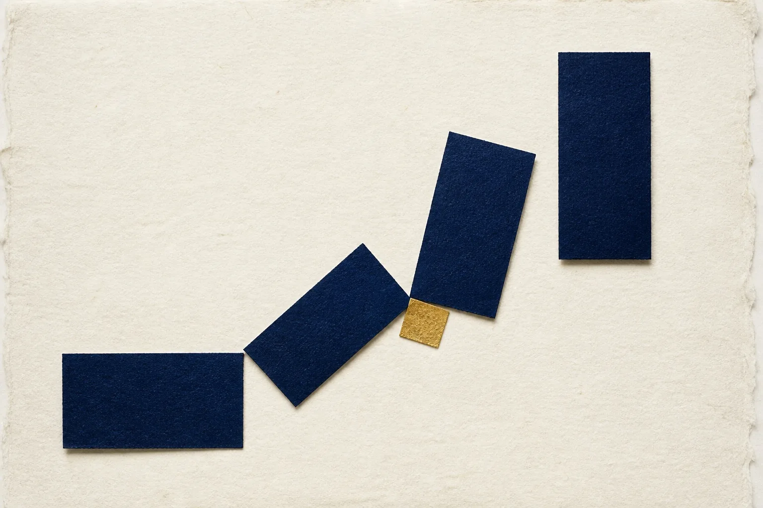 Paper artwork showing four indigo pivots and one small gold square